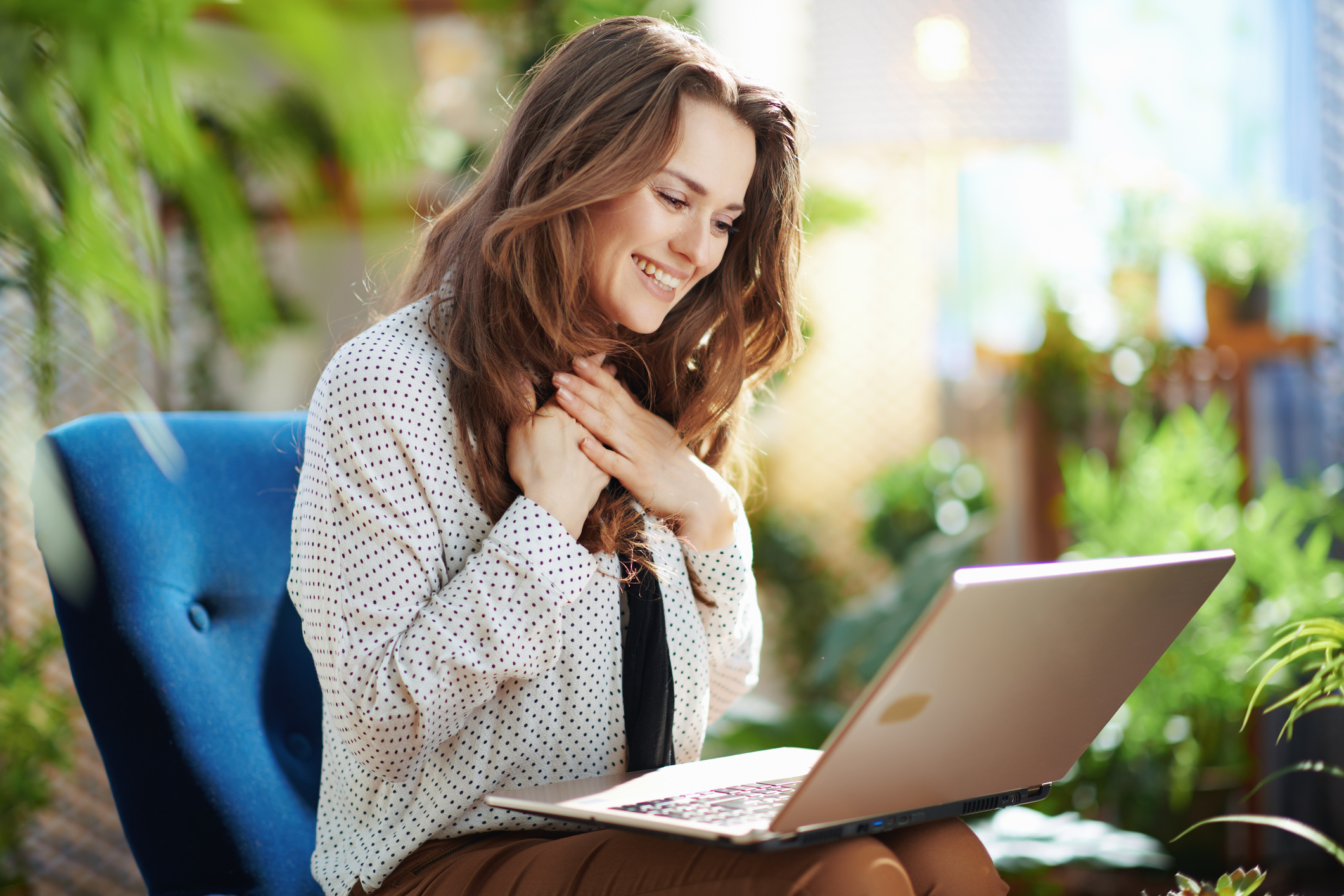 Psicóloga profesional sonriente trabajando eficientemente con su laptop en consultorio moderno usando Captta IA